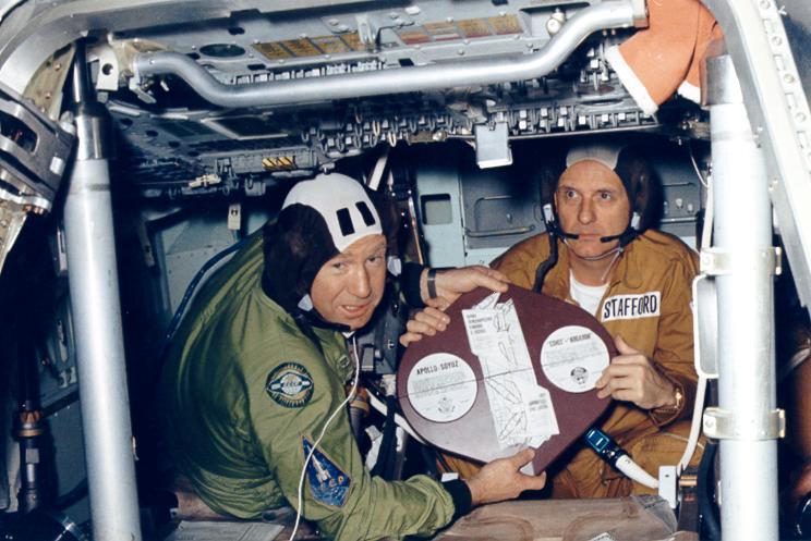 Leonov a Stafford skládají před kamerami dohromady plaketu, dokazující, že Apollo a Sojuz se spojily (Zdroj: NASA)