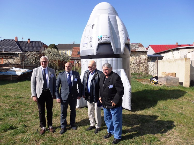 Kosmonauti nastoupení před nafukovací maketou kosmické lodi Crew Dragon od SpaceX v Bezděkově. Zleva Michal Fulier,  Ivan Bela (SR) a Vladimír Remek s Oldřichem Pelčákem (foto M. Rusiňák)