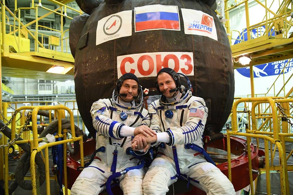 Oba astronauti pózují u Sojuzu MS-10