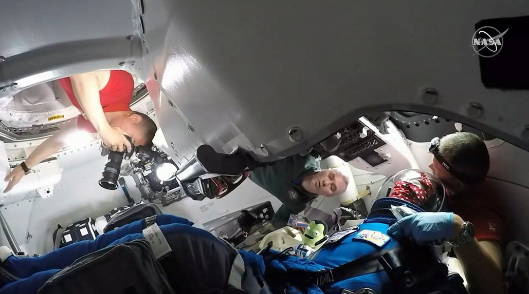 Členové osazenstva ISS na návštěvě ve Starlineru po jeho příletu. V popředí v modrém manekýnka Rosie Rocketeer. / Foto: NASA