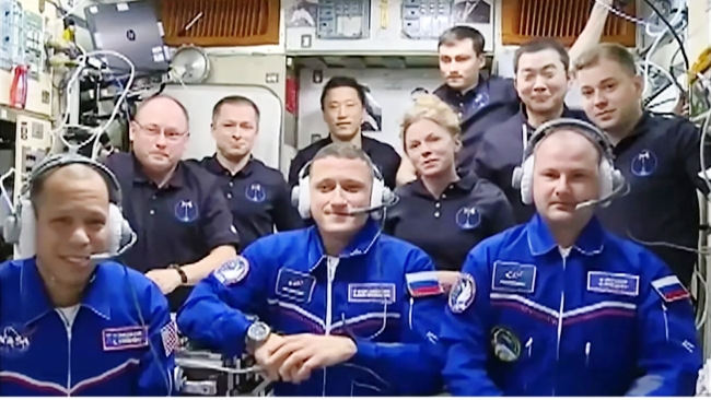 Tradiční uvítání „nováčků“ na stanici. V popředí zleva nováček Williams, Kuď-Sverčkov (2. start) a Mikajev (první let). Uprostřed mezi mužským osazenstvem Rižkov, Zubritský, Jonathan Kim, Fincke, Kimiya Jui a Platonov vykukuje jediná žena na ISS – Zena Cadrmannová
